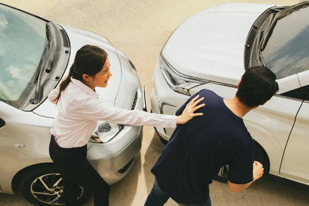 Angry woman quarrels and pushes man who suddenly cuts his car causing an accident on the road driving private car illegally causing damage to insurance liability : car insurance coの写真素材
