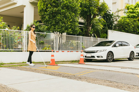 Blind asian young woman serious slowly crosses the street using a cane. for safety While walking carefully to the opposite side to prevent accidents : Accident insurance for the diの写真素材