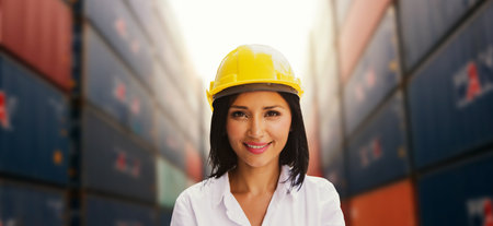 Business woman manager foreman smiling at you beautiful female worker using yellow safety helmet : Woman smart image working at container terminal shipping port logistics import, eの写真素材