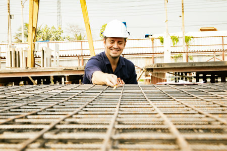 Architects inspect and control the production of steel bars by using tape measure to measure the prefabricated steel grating panel structure to meet the industry standards for placの写真素材