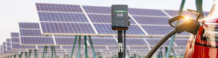 Electric vehicle EV plug cable into the lithium battery socket Cable charging stations in solar panel stations generate clean, eco friendly energy charging to reduce CO2 emissionsの写真素材