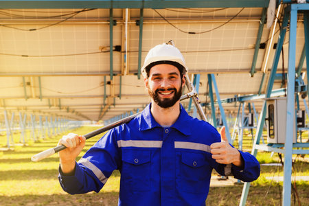 Male worker electrical engineer in charge of solar panels hand holding dirty solar panel cleaning tool Preparing cleaning work for field work look at thumbs up the camera and smileの写真素材