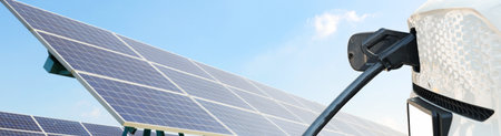 Electric vehicles charge clean and eco-friendly energy to reduce CO2 emissions and pollution made from solar cell : Plug the electric vehicle's EV cable into the front lithium battの写真素材