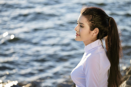 Beautiful woman in Vietnam culture traditional relaxing on lake beside blue waterの写真素材