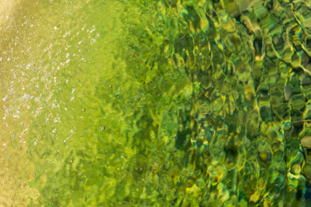 Yellow-green surface of flowing water close up backgroundの写真素材