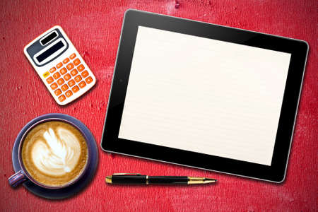 Touch screen device and stationery with cup of coffee on  Grunge Red wooden  backgroundの写真素材