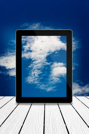Tablet computer on wood,cloudy sky computing technology conceptの写真素材