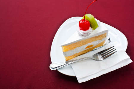 Piece of fruit cake on red tablecloth.