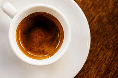 White cup of coffee on wooden background の写真素材