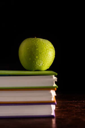 Stack books and green appleの写真素材
