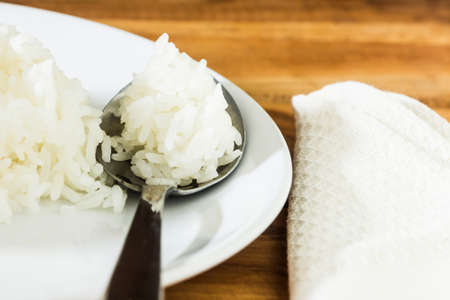 Rice in dish with white napkin on wood tableの写真素材