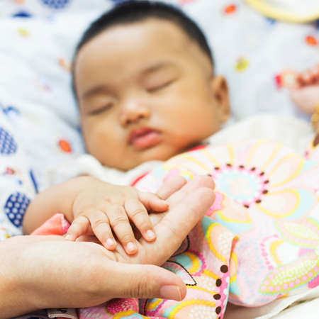 hand the sleeping baby in the hand of mother close-up の写真素材
