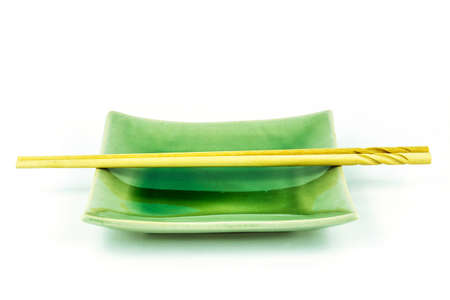 Empty green dish with chopsticks isolated on white backgroundの写真素材