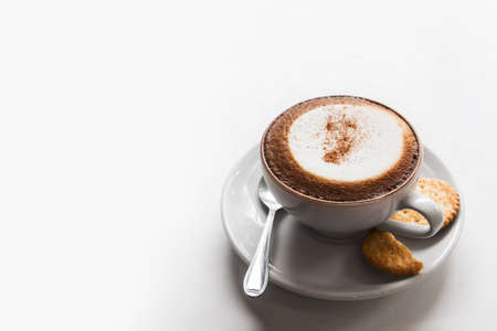 Cappuccino cup of coffee with cracker isolated on white background.の写真素材