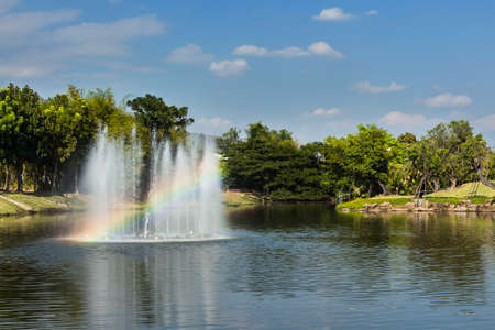 Fountain with rainbow in the artificial pond.の写真素材