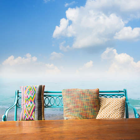 bench and wood table against seascapeの写真素材