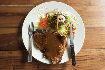 T bone steak in white plate on tableの写真素材
