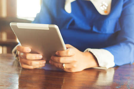 woman using tablet computer in cafe. Focus on tablet.の写真素材