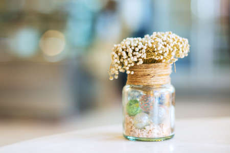 Dried flowers in glass bottle on wood table decorations in cafe. Selective focus.の写真素材
