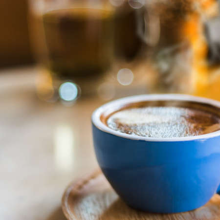 Close up coffee cup with steam on table in cafe. Selective focus.の写真素材