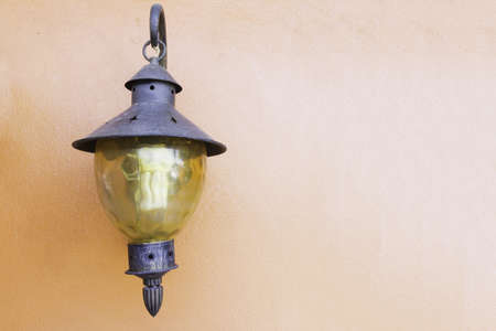 Vintage lamp on orange concrete background.