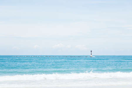 Lighthouse over a nice view of blue sea.の写真素材