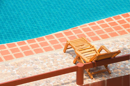 Deck chair near swimming pool in tropical resort.の写真素材
