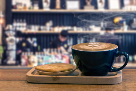 Cup of coffee on wood table with blur cafe background.の写真素材