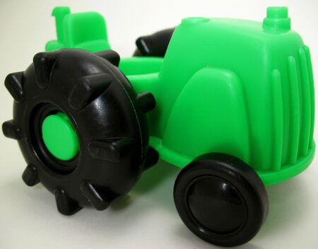 A baby's green tractor toy with enlarged black wheels.の写真素材