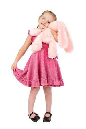 little girl in pink dress  hugging a pink toy rabbitの写真素材