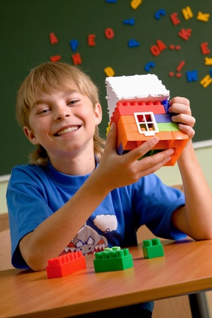 schoolboy with small house from blocksの写真素材
