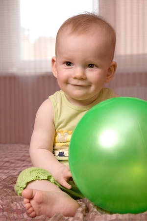 Little baby with green ballの写真素材