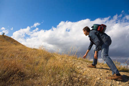 man with backpack climbing a rockの写真素材