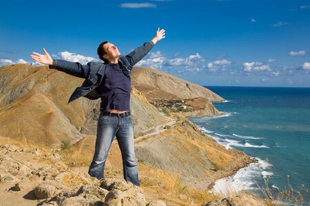 Happy man stands on the mountainの写真素材