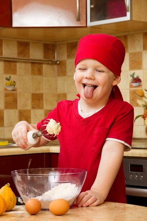 Small boy helping at kitchen with baking a pie, little chefの写真素材