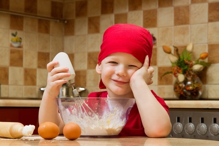 Small boy helping at kitchen with baking a pie, little chefの写真素材