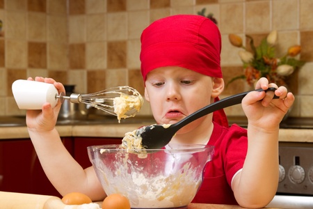 Small boy helping at kitchen with baking a pie, little chefの写真素材