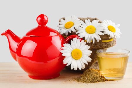  healthy chamomile tea, red teapot and sack with daisiesの写真素材