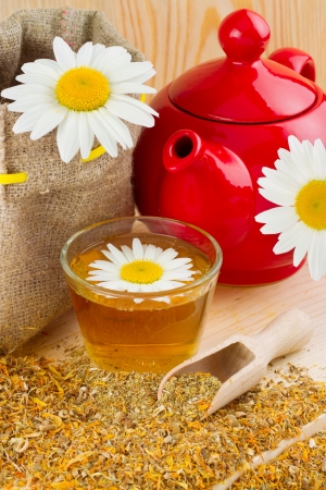 healthy chamomile tea, red teapot and sack with daisiesの写真素材