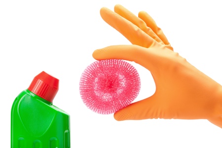 hand in rubber glove with scrub pad and bottles of cleaning productの写真素材