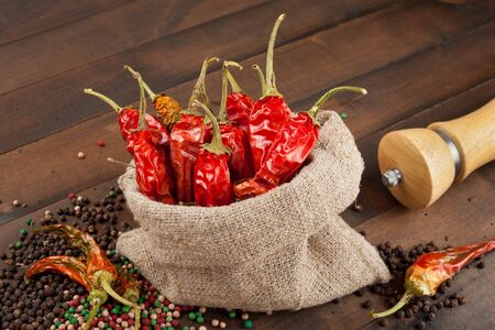 red chili peppers  in a canvas sack on wooden tableの写真素材