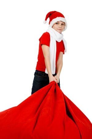 Boy in Santa Claus hat with red Christmas Gift Bag on whiteの写真素材