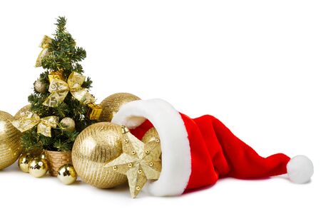 golden baubles in Santa Claus hat and Christmas tree with gifts, bows and balls on white backgroundの写真素材