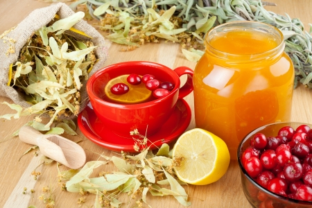 cranberries, jar with honey, fruit tea cup, healing herbs and lemonの写真素材