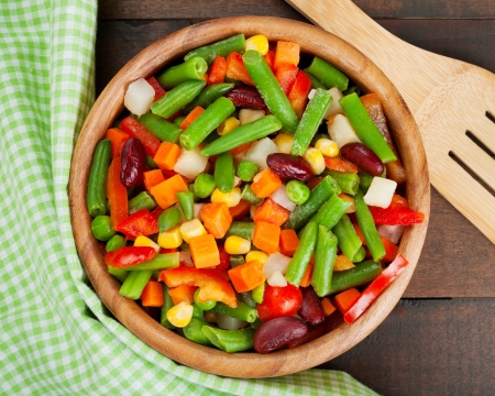 mixed vegetables in wooden bowl on kitchen tableの写真素材