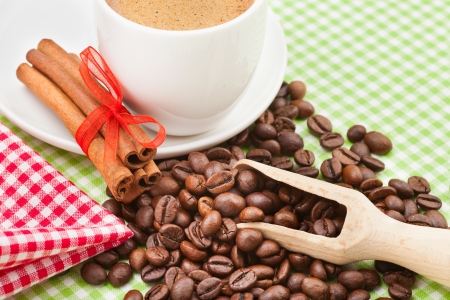 coffee cup, cinnamon sticks and coffee beans on kitchen tableの写真素材