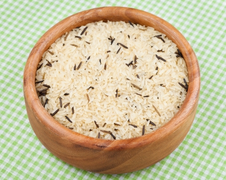 white and wild rice in wooden  bowl on kitchen tableの写真素材