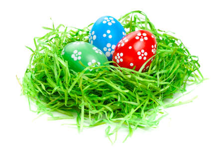 easter eggs in straw nest on white
