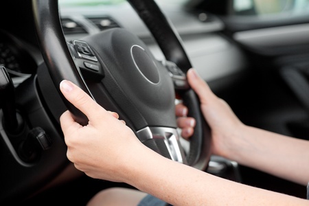 woman hands holding steering wheel in luxury carの写真素材