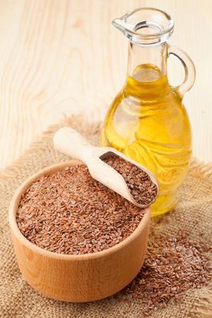  mortar of flax seeds with wooden scoop and linseed oil in glass jugの写真素材